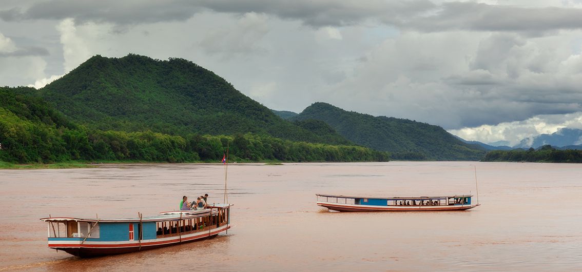 Langboote am Mekong in Laos